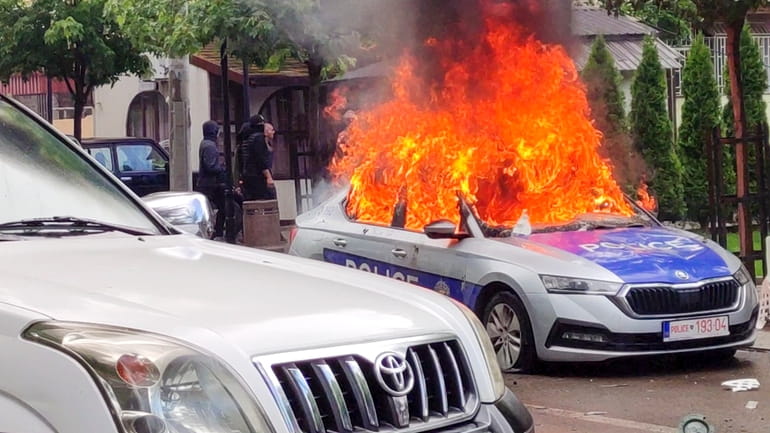 In this image made from video, Kosovar police car burns...