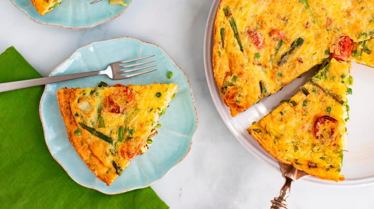 A simple spring frittata with asparagus, sweet peas, tomatoes and...
