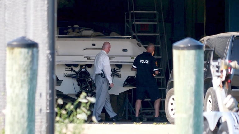 Nassau County police inspect a boat that was impounded after...