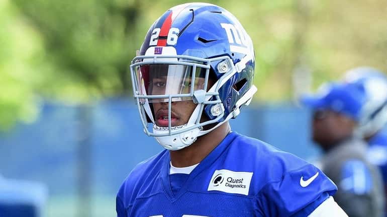 Giants running back Saquon Barkley looks on from the field...