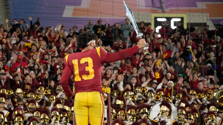 Southern California quarterback Caleb Williams leads the USC Marching Band...