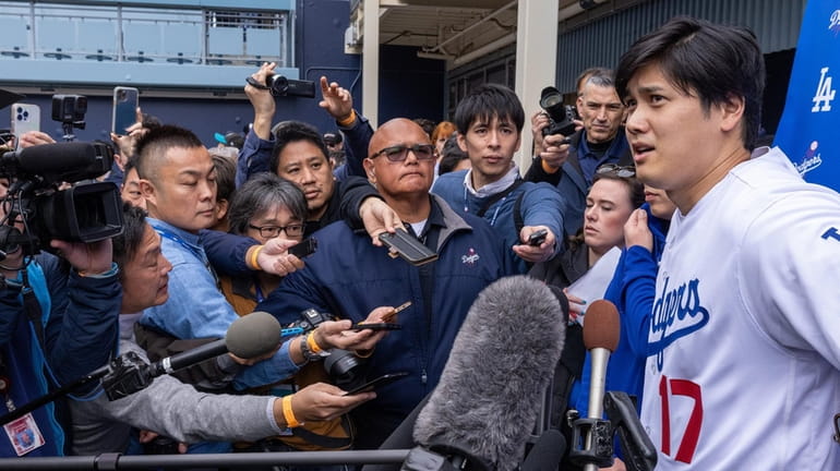 The Dodgers' Shohei Ohtani talks with media during DodgerFest 2024...