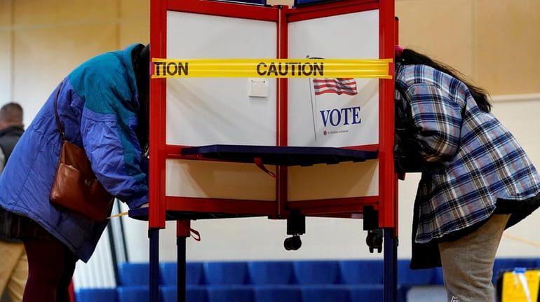Caution tape closes off a voting stall to distance voters...
