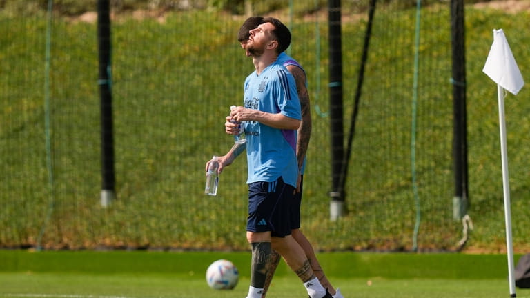 Lionel Messi enters to the pitch for a training session...