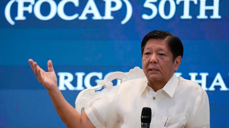 Philippine President Ferdinand Marcos Jr. gestures as he answers questions...