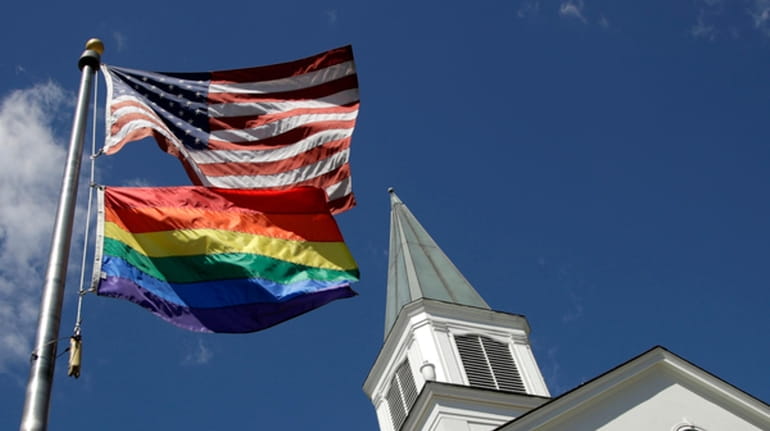 A gay pride rainbow flag flies along with the U.S....