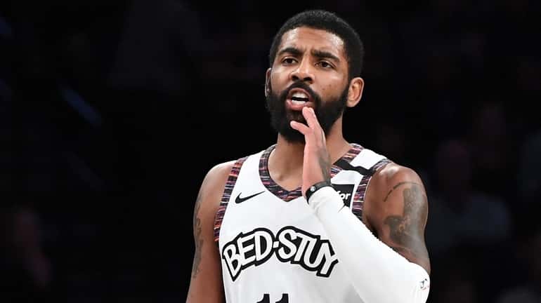 Nets guard Kyrie Irving calls to a teammate during the...