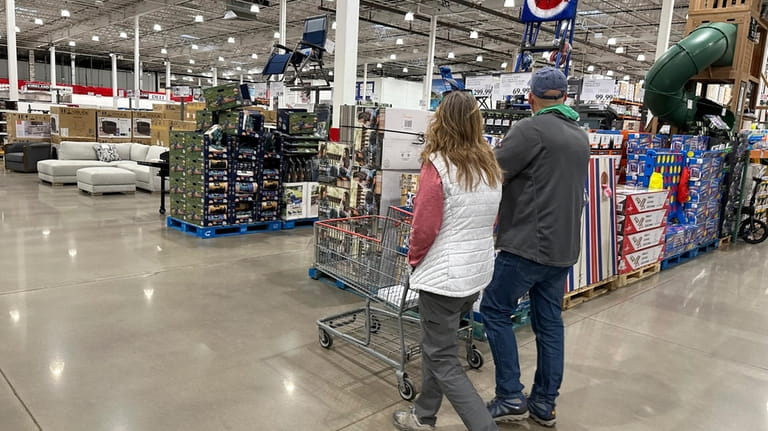 Shoppers pass displays of goods in a Costco warehouse Sunday,...