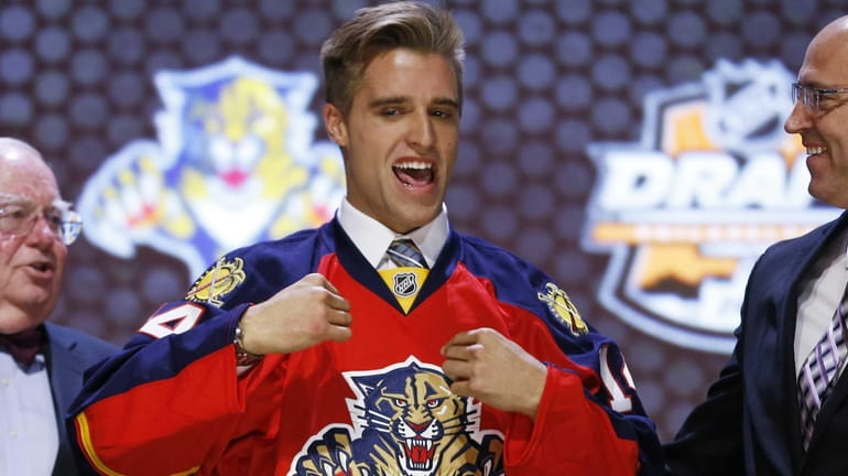 Aaron Ekblad pulls on a Florida Panthers sweater after being...