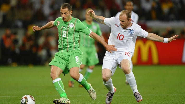 Wayne Rooney of England challenges Medhi Lacen of Algeria during...