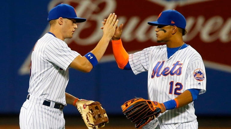 Brandon Nimmo #9 and Juan Lagares #12 of the New...
