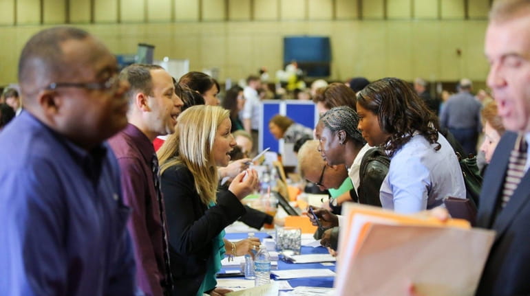 Job seekers speak with prospective employers during the Nassau County...