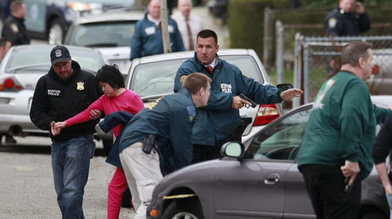 A neighbor is escorted to safety as police surround a...