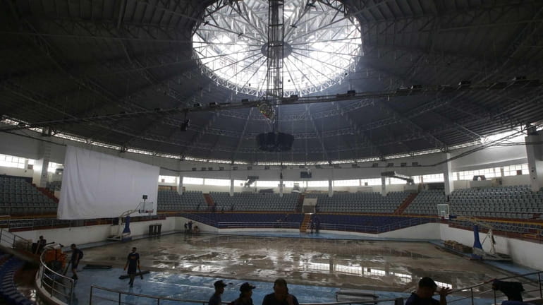 Philippine Navy Seabees clean the typhoon-damaged Tacloban Astrodome to pave...