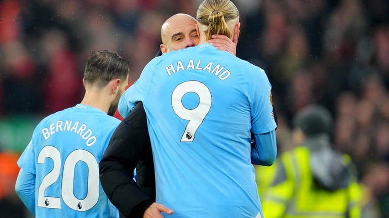 Manchester City's head coach Pep Guardiola hugs Erling Haaland after...