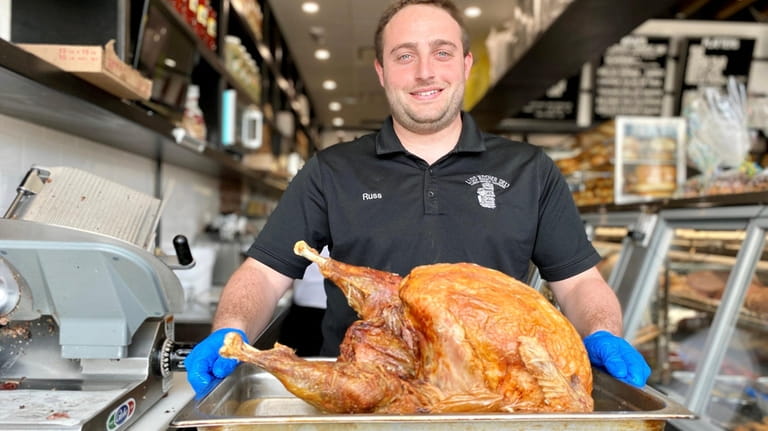 Russell Goetz, partner, hefts a roasted turkey at Lido Kosher...