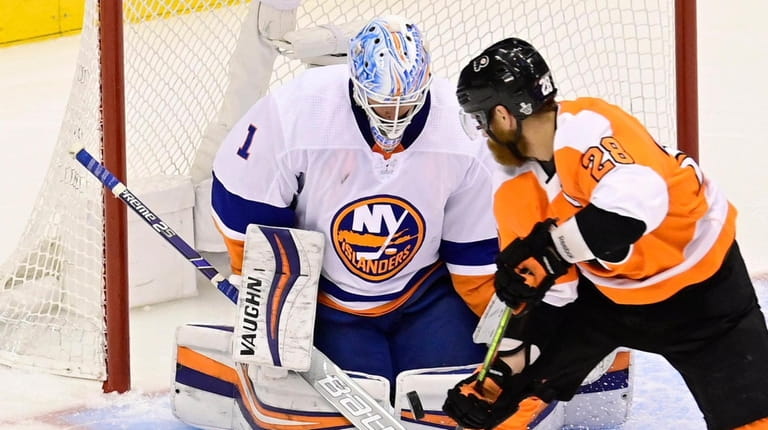 Islanders goaltender Thomas Greiss stops Flyers left wing Claude Giroux during first-period...