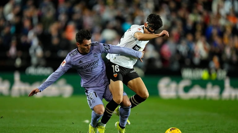 Real Madrid's Brahim Diaz, left, and Valencia's Diego Lopez battle...