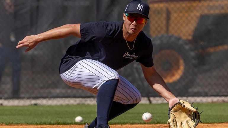 Yankees' Anthony Volpe fielding balls during spring training in George...