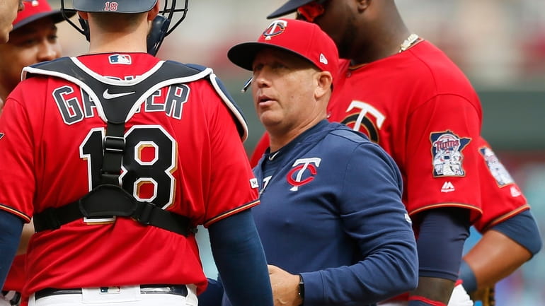 FILE - Minnesota Twins pitching coach Wes Johnson, right, holds...