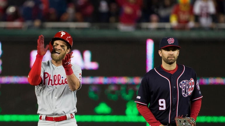 Philadelphia Phillies' Bryce Harper, left, celebrates his RBI hit while...