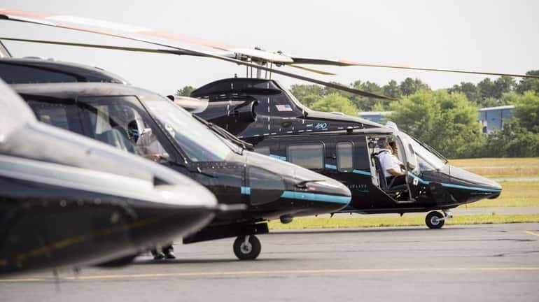 Helicopters sit on the tarmac at East Hampton Town Airport...
