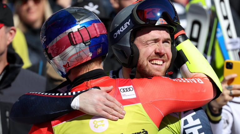 Norway's Aleksander Aamodt Kilde, right, hugs Switzerland's Marco Odermatt at...