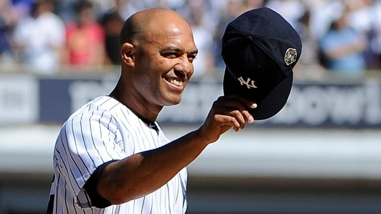 The Yankees' Mariano Rivera stands on the mound and tips...