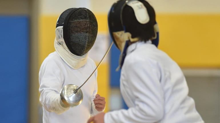 Brian Li of Jericho, left, competes in an epee bout...