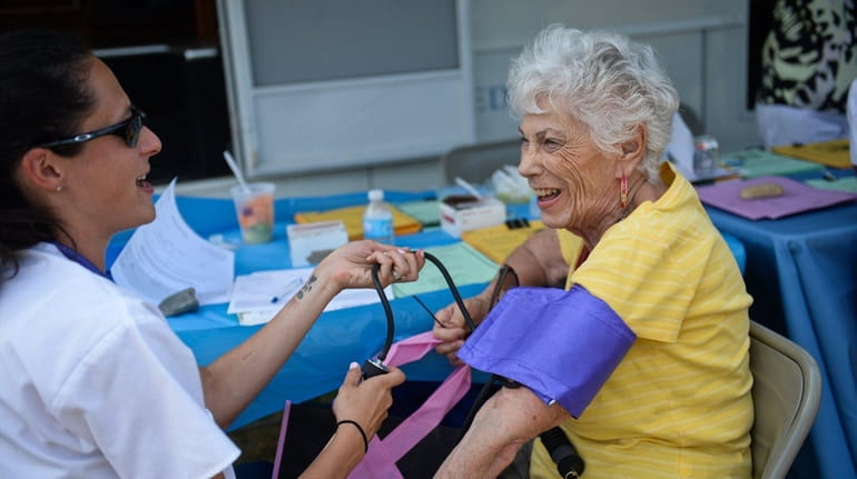 Winthrop nurse Christine Pagano, left, takes the blood pressure of...