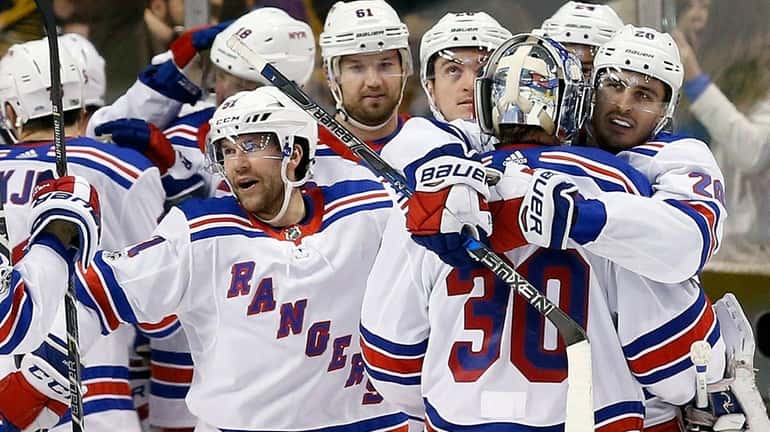 Rangers goalie Henrik Lundqvist celebrates with teammates after defeating the...