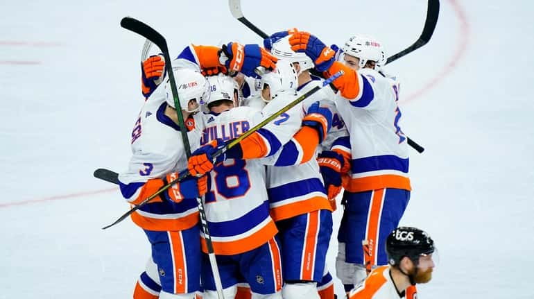 Islanders' Anthony Beauvillier (18) celebrates with teammates past Philadelphia Flyers'...