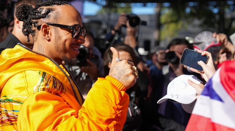 Mercedes driver Lewis Hamilton of Britain gestures to fans as...