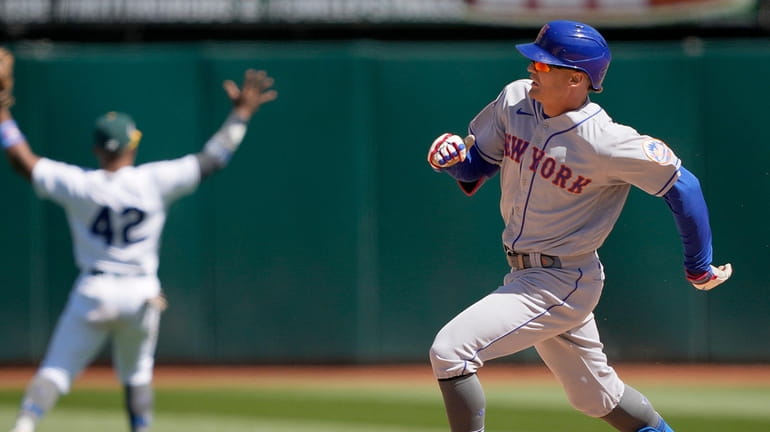 Brandon Nimmo of the New York Mets races into second base...
