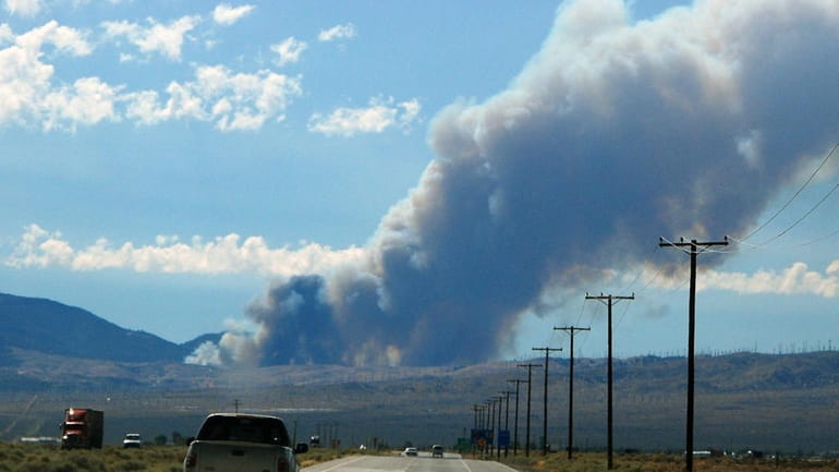 A huge column of smoke from the West Fire can...