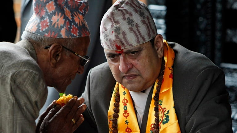 Nepal's former King Gyanendra, right, listens to a supporter on...