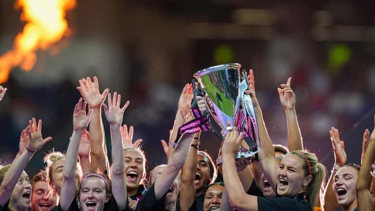 United States' players hold the trophy as they celebrate winning...