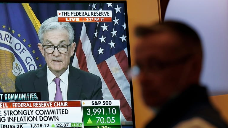 Traders watch as the Federal Reserve announces a rate change on July...