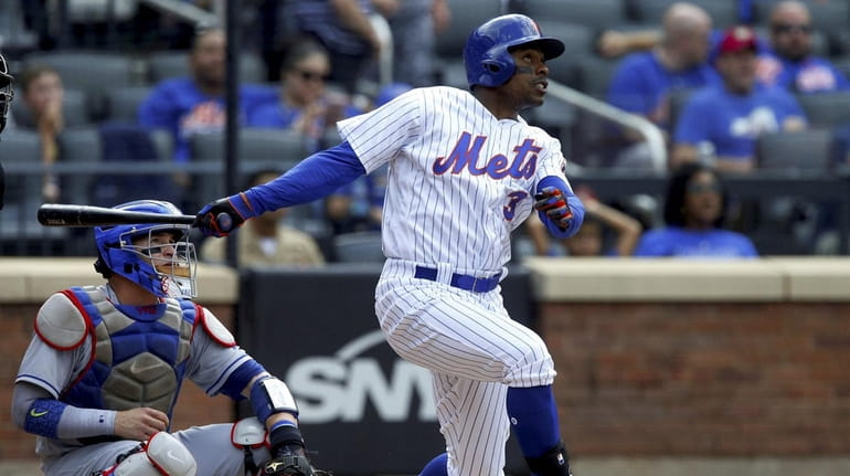 Curtis Granderson of the Mets follows through on his home...