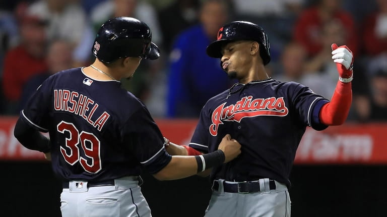 Cleveland's Gio Urshela congratulates Francisco Lindor after his two-run homer at Angel...