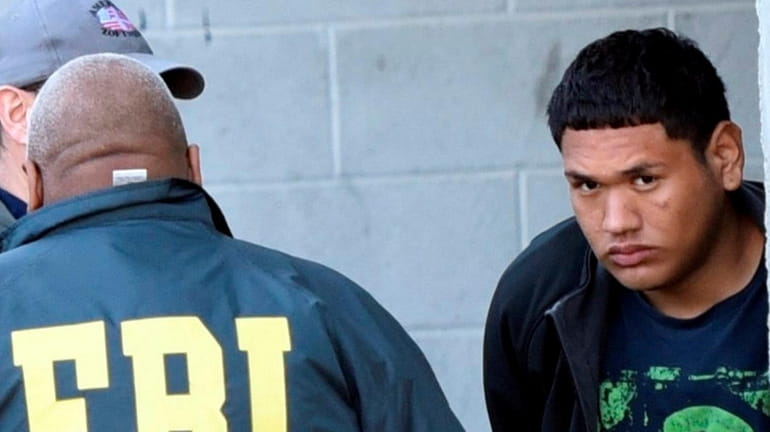 The FBI takes MS-13 gang member Enrique Portillo, right, into...