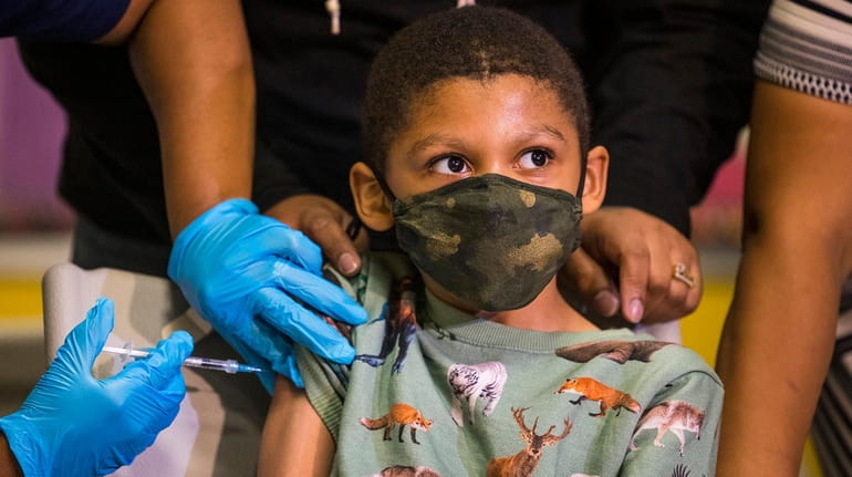 Christopher Reyes, 9, gets a COVID-19 vaccination at a pop-up...