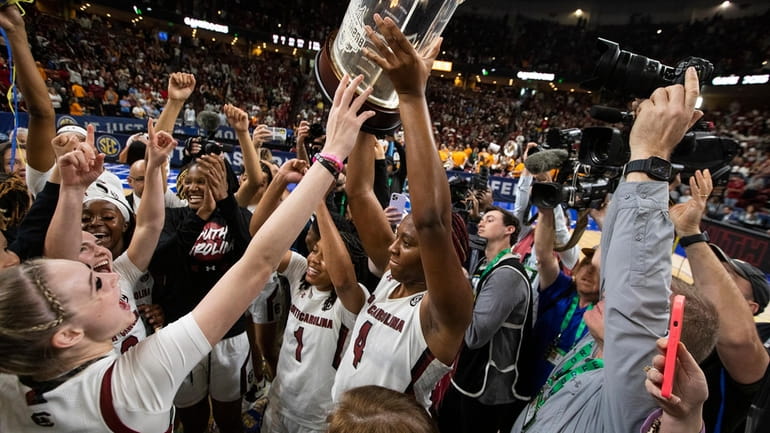 South Carolina's Aliyah Boston holds up the championship trophy after...
