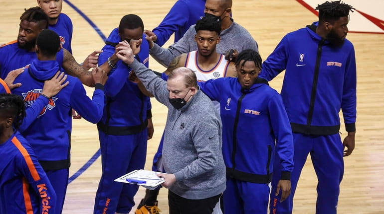New York Knicks head coach Tom Thibodeau, center, huddles with...