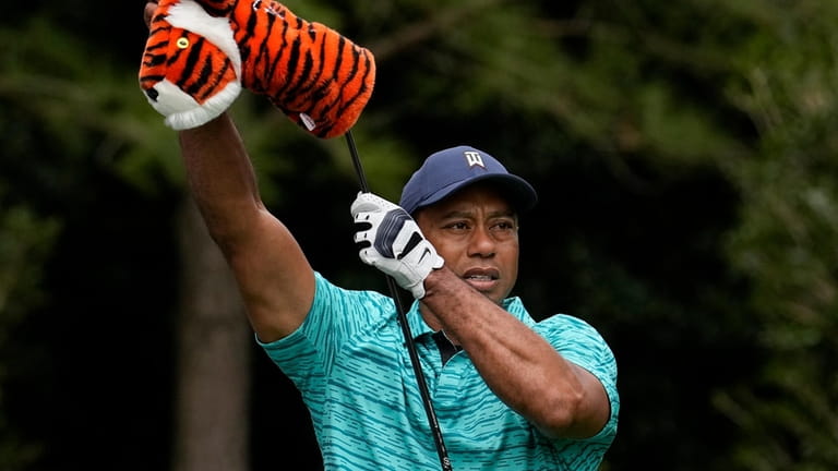 Tiger Woods takes the head cover off of his driver...