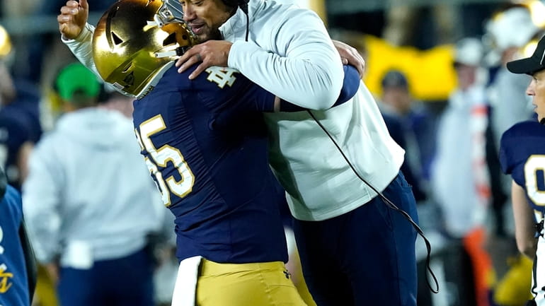 Notre Dame head coach Marcus Freeman is lifted in the...