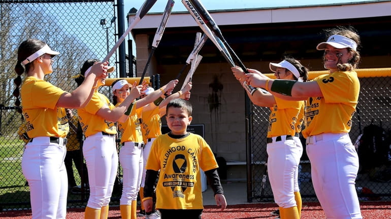 Ward Melville softball players make a tunnel of bats for...