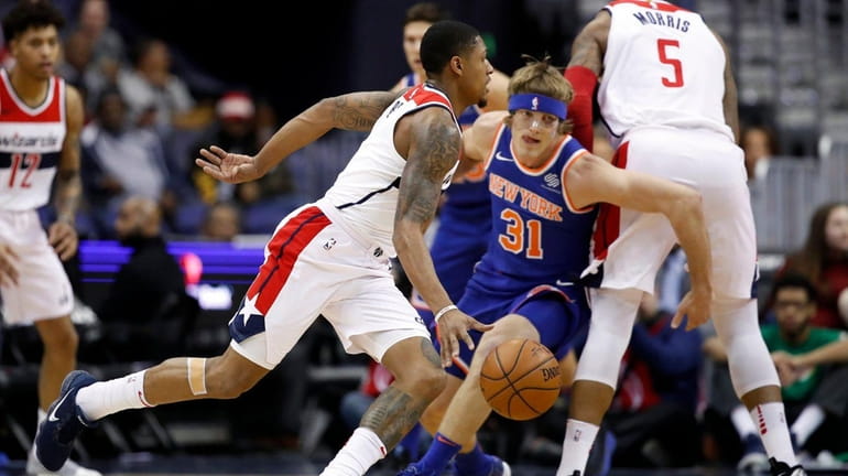 Wizards guard Bradley Beal tries to get away from Knicks...