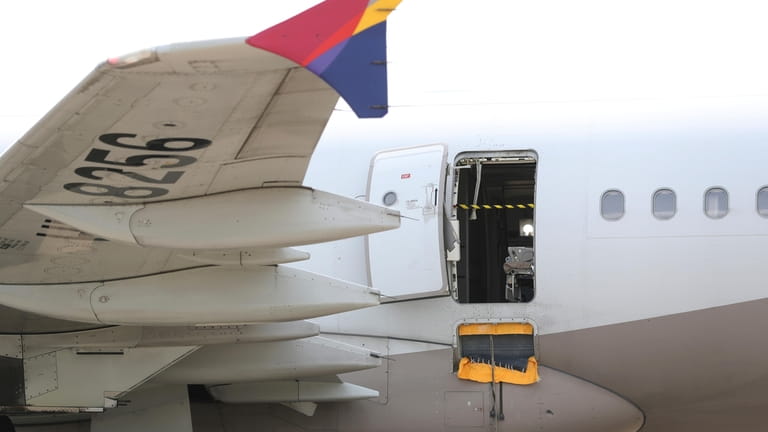 An Asiana Airlines plane is parked as one of the...