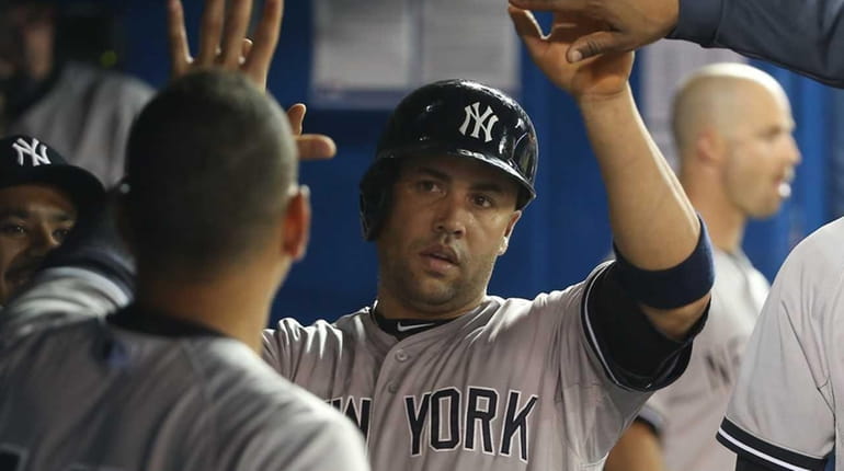 Carlos Beltran #36 of the New York Yankees is congratulated...